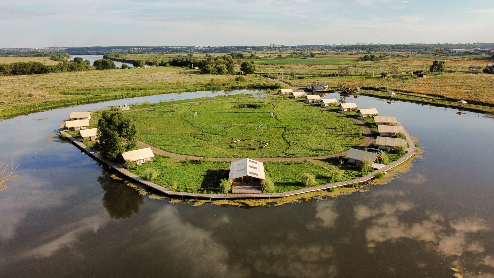 Aerial view of Ostrov Glamping on Lake Kopyto at golden hour, Moscow region