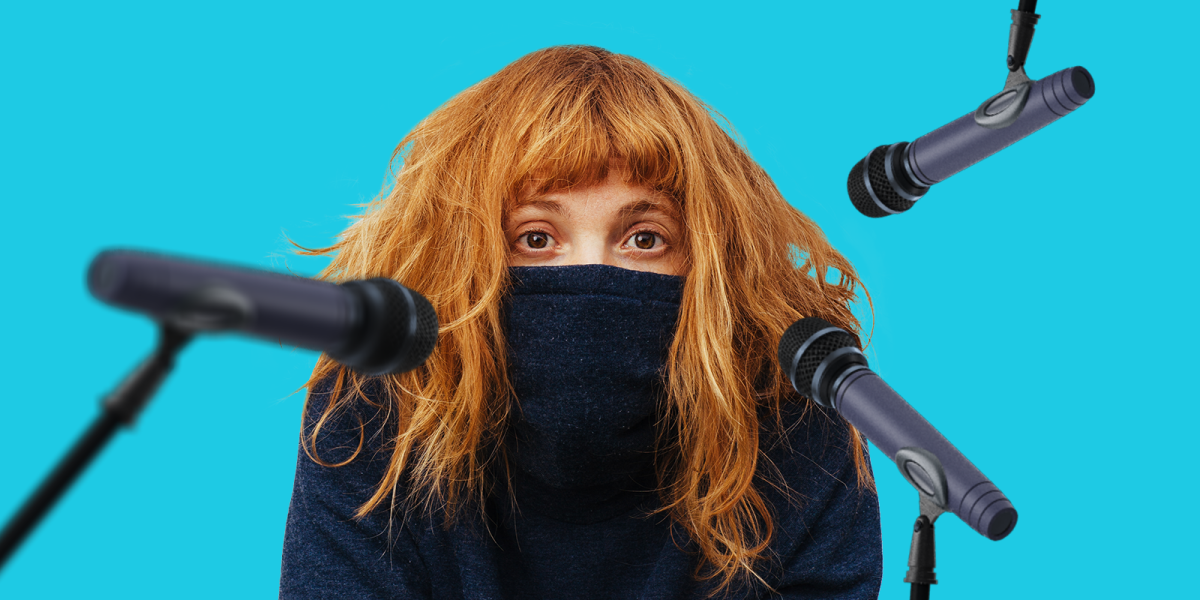 рыжая девушка в маске дает интервью