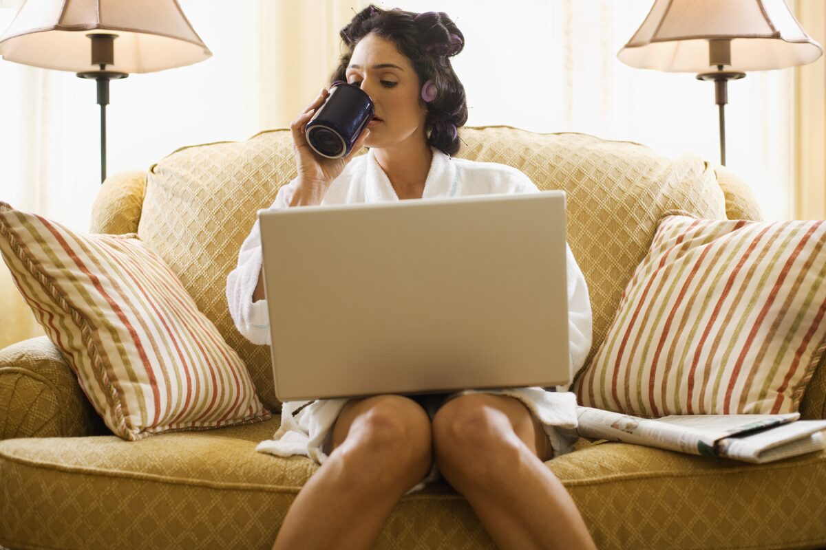 Женщина на диване с ноутбуком