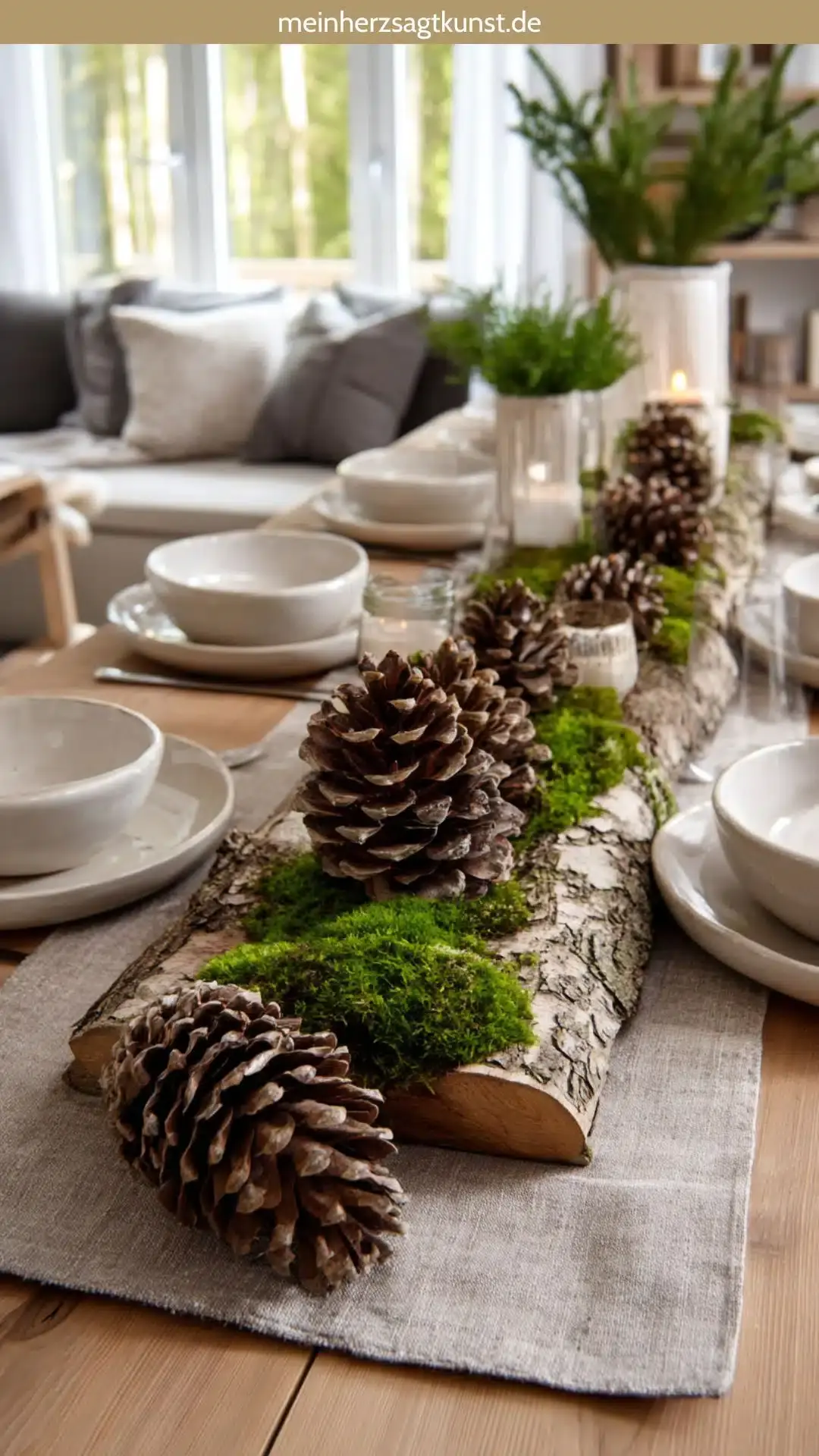 Украшение стола в природном стиле: крупные сосновые шишки, кора деревьев и зеленый мох на светлом деревянном столе.