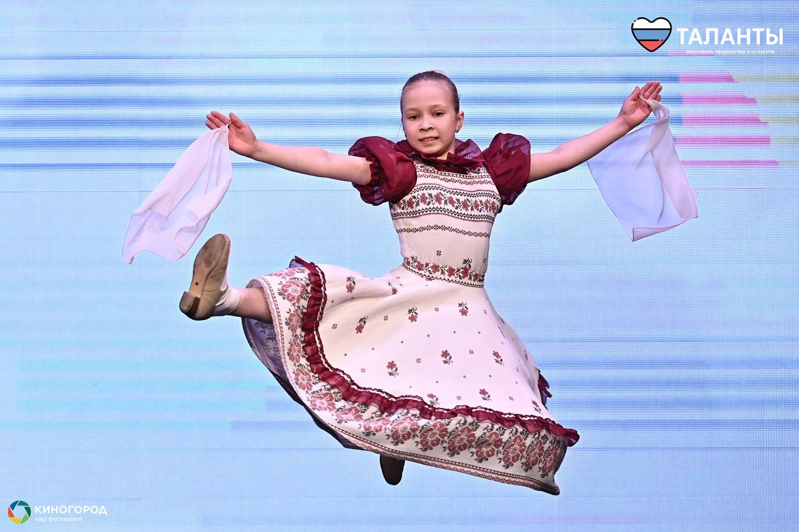 Танцовщица в розовом костюме исполняет прыжок на сцене фестиваля «Таланты», архив