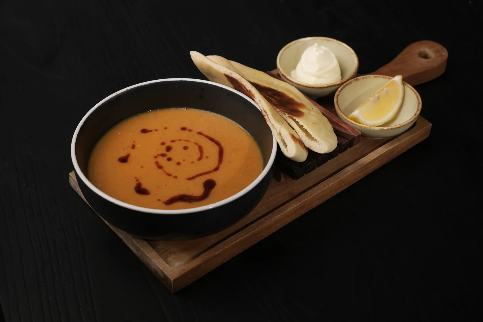 Creamy red lentil soup served with garlic flatbread and lemon at Eden Hookah Club, a spot for the best halal food in Uluwatu