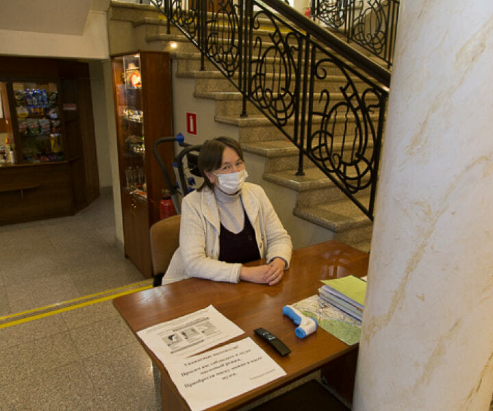 Сотрудница музея сидит за столом у входа