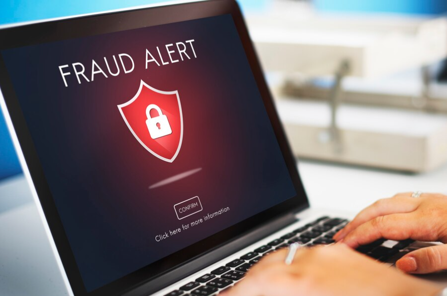 Binance P2P scams: A laptop with a sign indicating a fraud or scam alert on Binance P2P