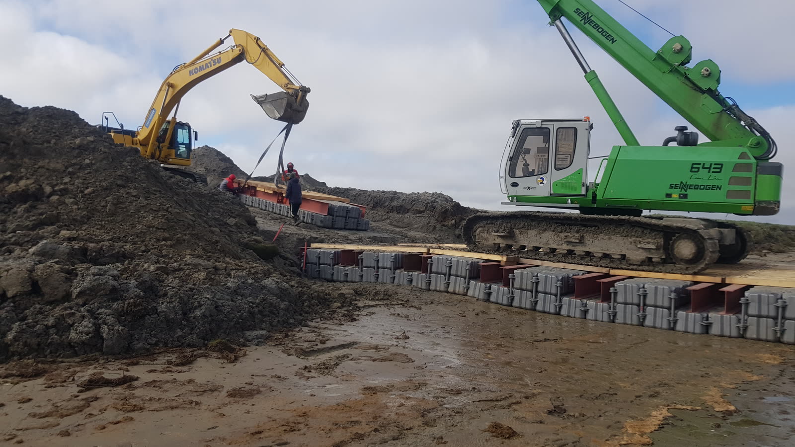 Техника на понтонной насыпи в море, пасмурная погода
