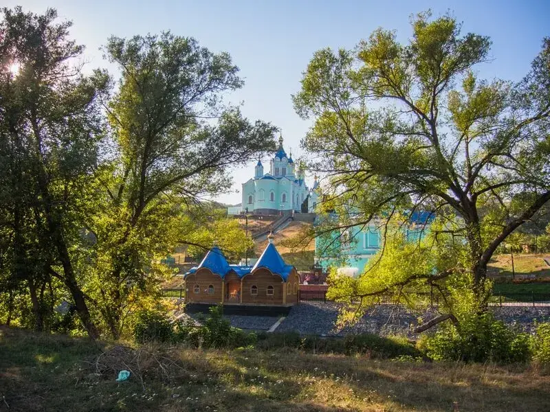 Коллаж, посвящённый археологическим исследованиям Тереховского городища: раскопки древнего захоронения, работа археологов с находками, панорама памятника археологии на берегу реки и обнаруженные артефакты — украшения, кресты, подвеска и элементы древнего костюма, отражающие историко-культурное наследие средневековой Руси.