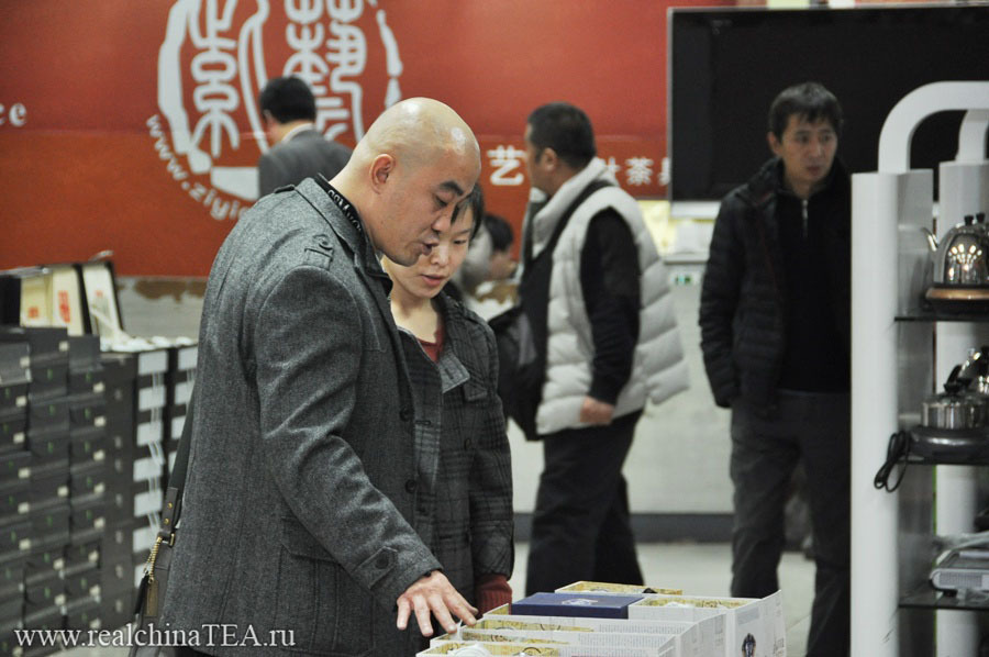 Серьезный китайский мужчина покупает дорогую посуду