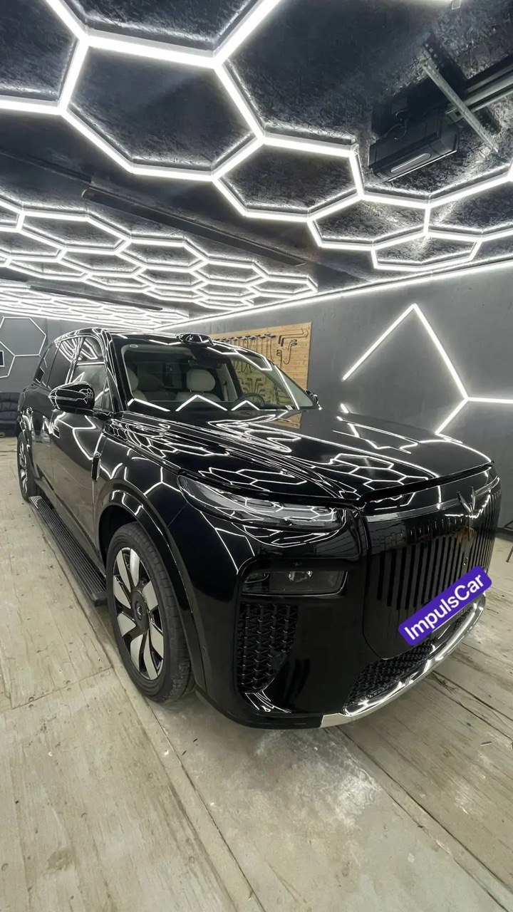 Чёрный автомобиль в мастерской ImpulsCar во время работ с защитной плёнкой
