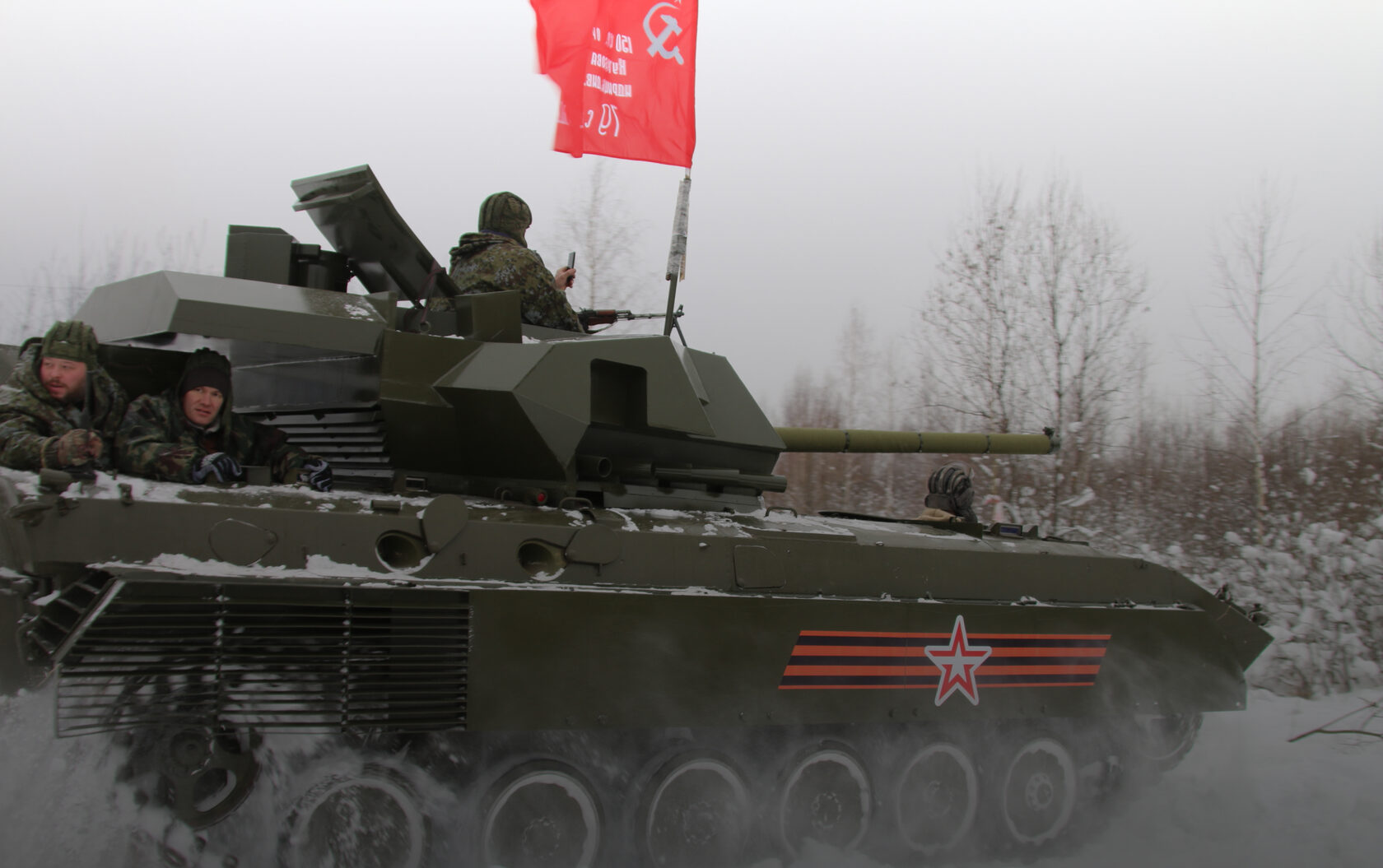 Участники на бронетехнике с красным флагом на полигоне
