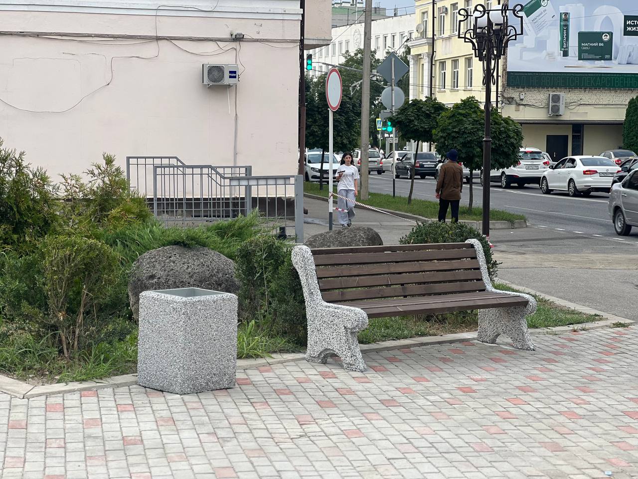 Скамейка и урна на площадке у городского здания