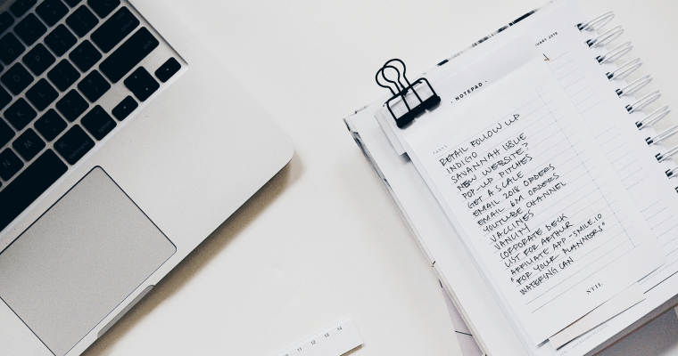 блокнот и ноутбук на столе вид сверху