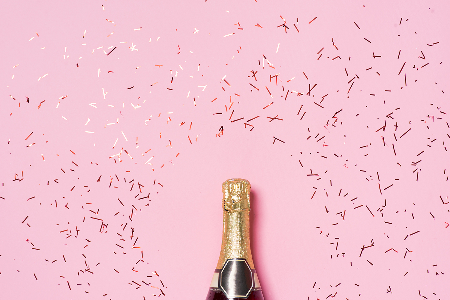 Бутылка шампанского на розовом фоне