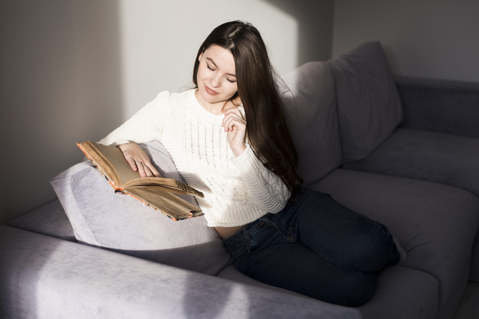 Девушка на диване с книжкой