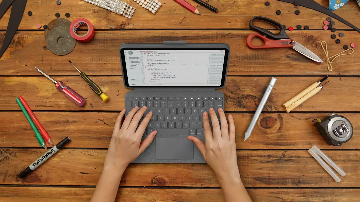 Чехол-клавиатура Logitech Combo Touch в работе: iPad стоит на подставке, клавиатура подключена, пользователь печатает.
