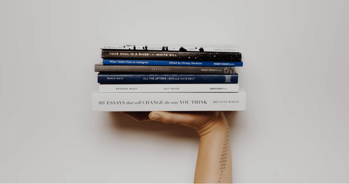 рука держит стопку книг