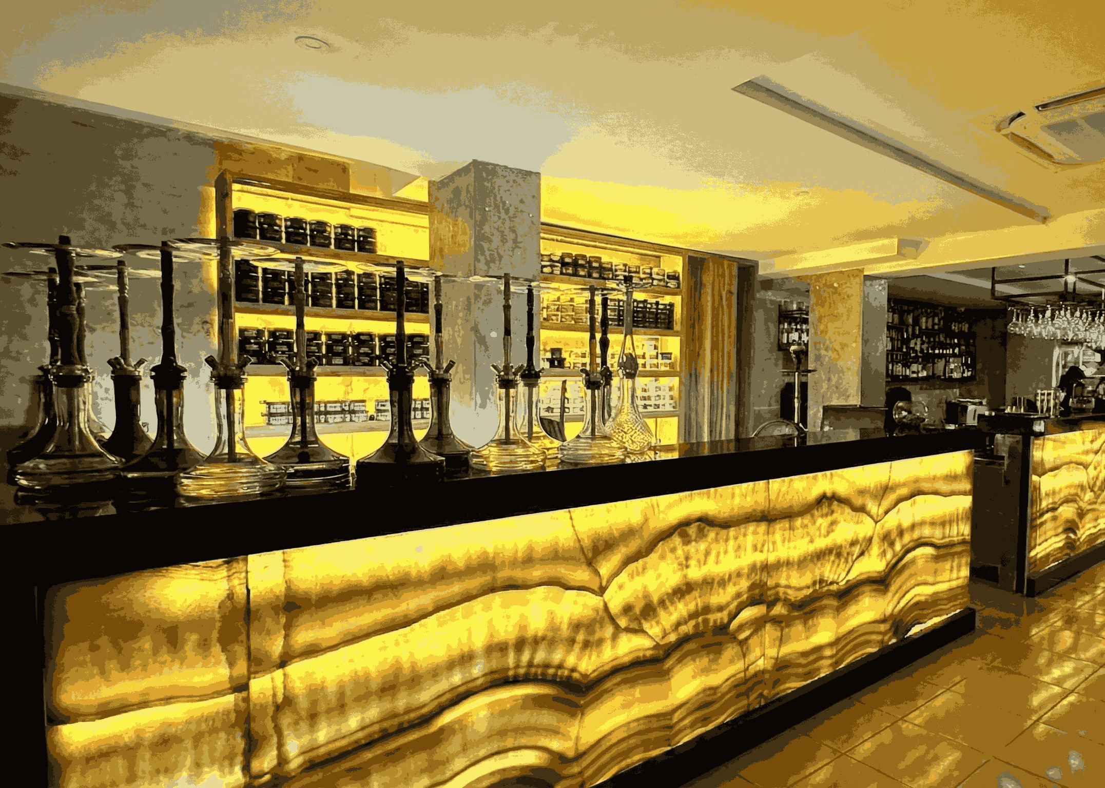 The glowing bar counter displaying an extensive hookah selection at Eden Lounge, a top destination for halal food in Ubud.