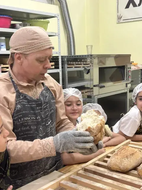 Мастер помогает ребёнку достать свой хлеб