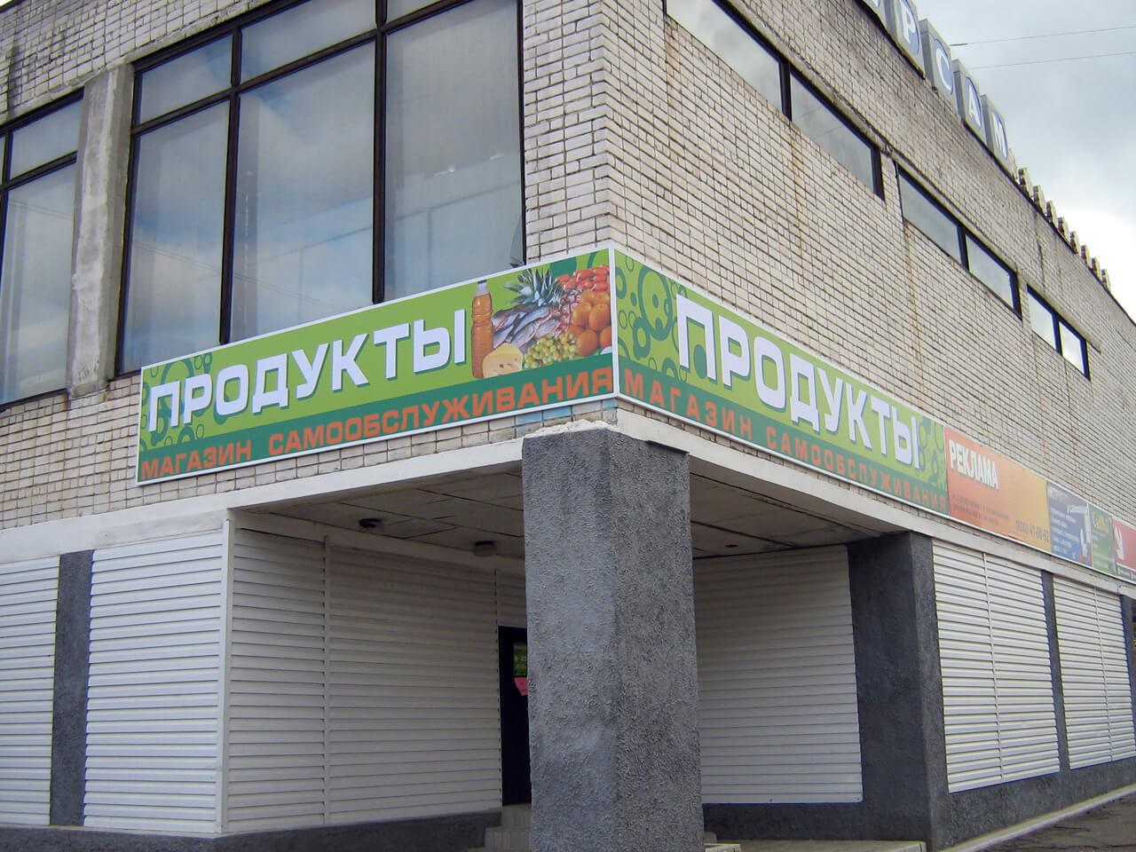 Вывеска на углу здания для продуктового магазина