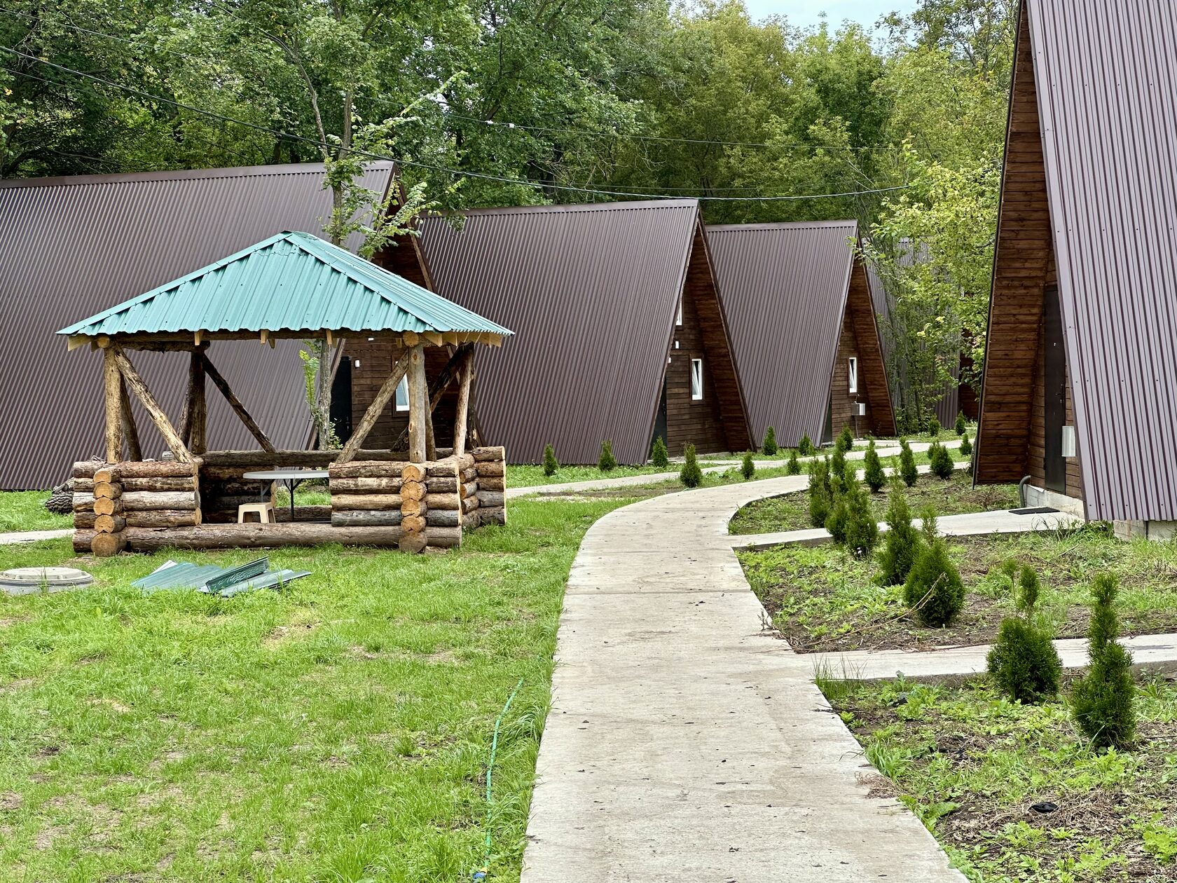 Домики A-frame базы отдыха «Река и Лес» среди деревьев