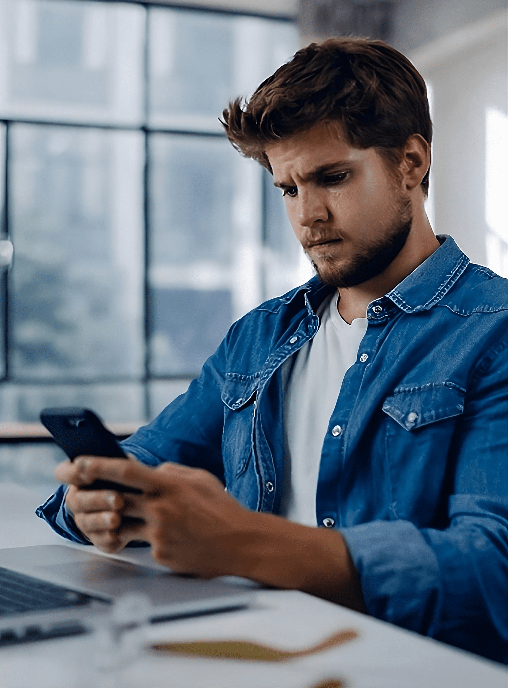 Мужчина смотрит в телефон, набирает номер телефона нашей компании чтобы позвонить и сделать заказ