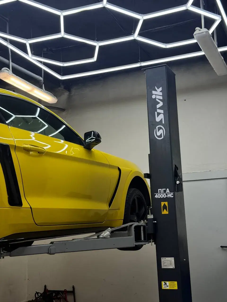 Жёлтый Ford Mustang на подъёмнике