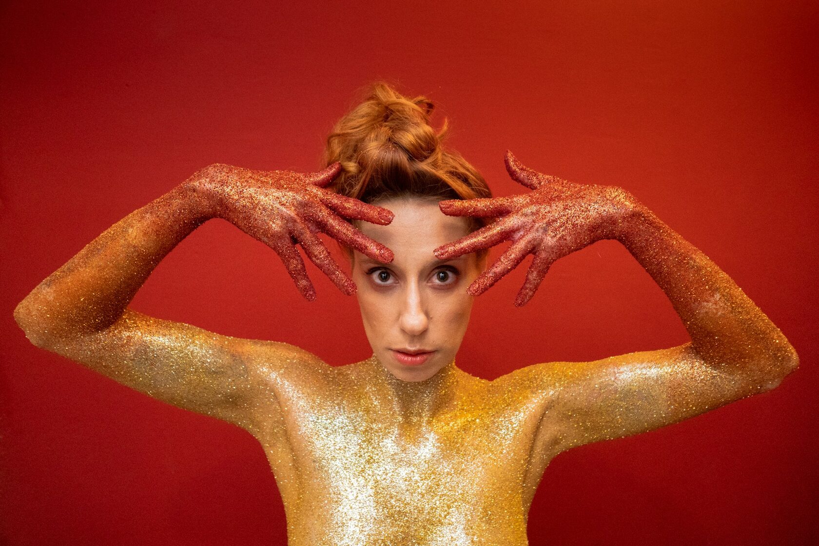 Fashion editorial body art with gold shimmer details on a model