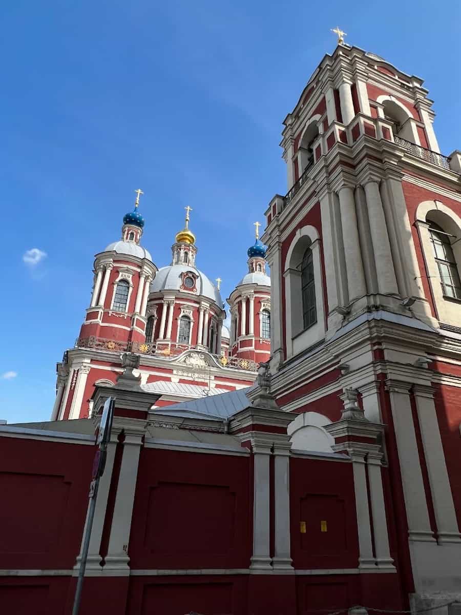 Красно-белая колокольня и купола храма в Замоскворечье