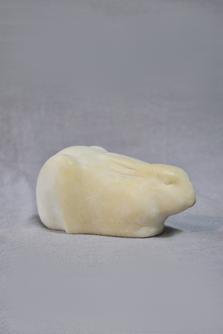 каменная статуэтка заяц лежит