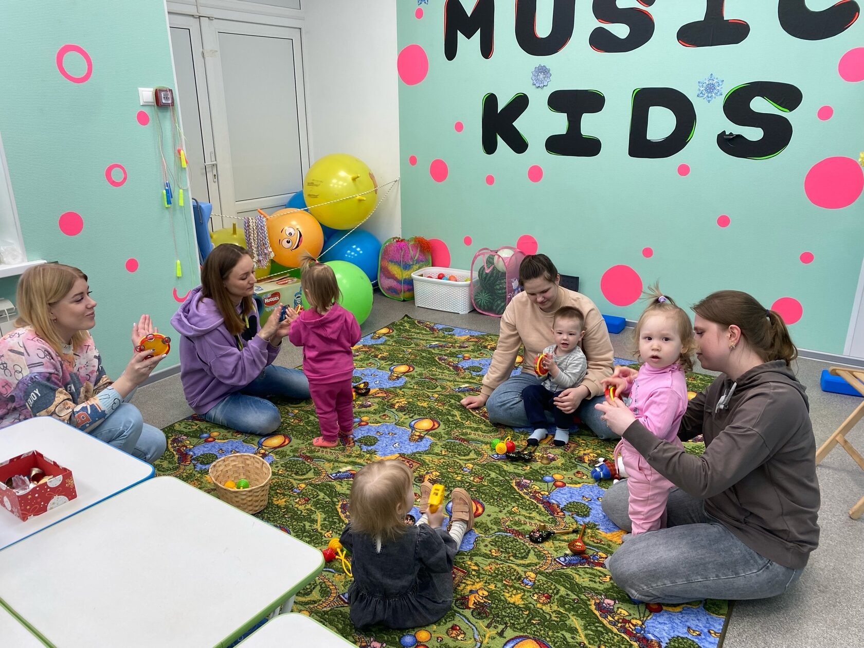 мамы с малышами на совместном занятии по раннему развитию в детском клубе