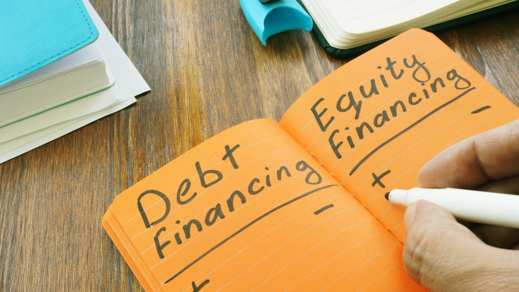 A notepad lists debt financing and equity financing, which could indicate a hybrid financing strategy.
