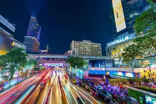 Ночная улица у CentralWorld в Бангкоке со световыми следами машин