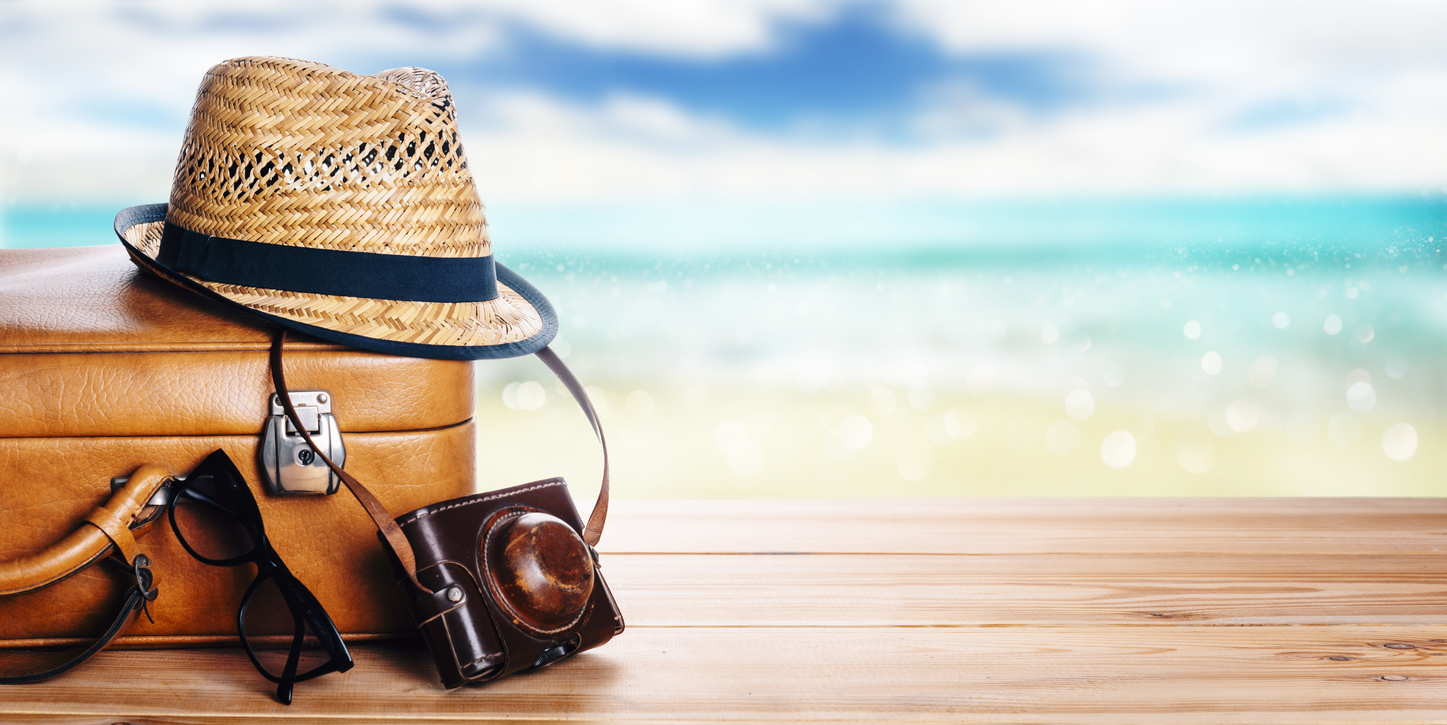 A traveller&amp;amp;amp;amp;amp;amp;amp;amp;amp;amp;amp;amp;amp;amp;#39;s hat and luggage on the beach with blue waves.