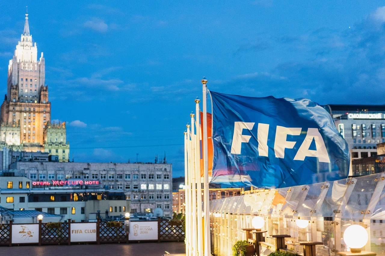 Флаг FIFA на фоне сталинской высотки в Москве и вечерней подсветки