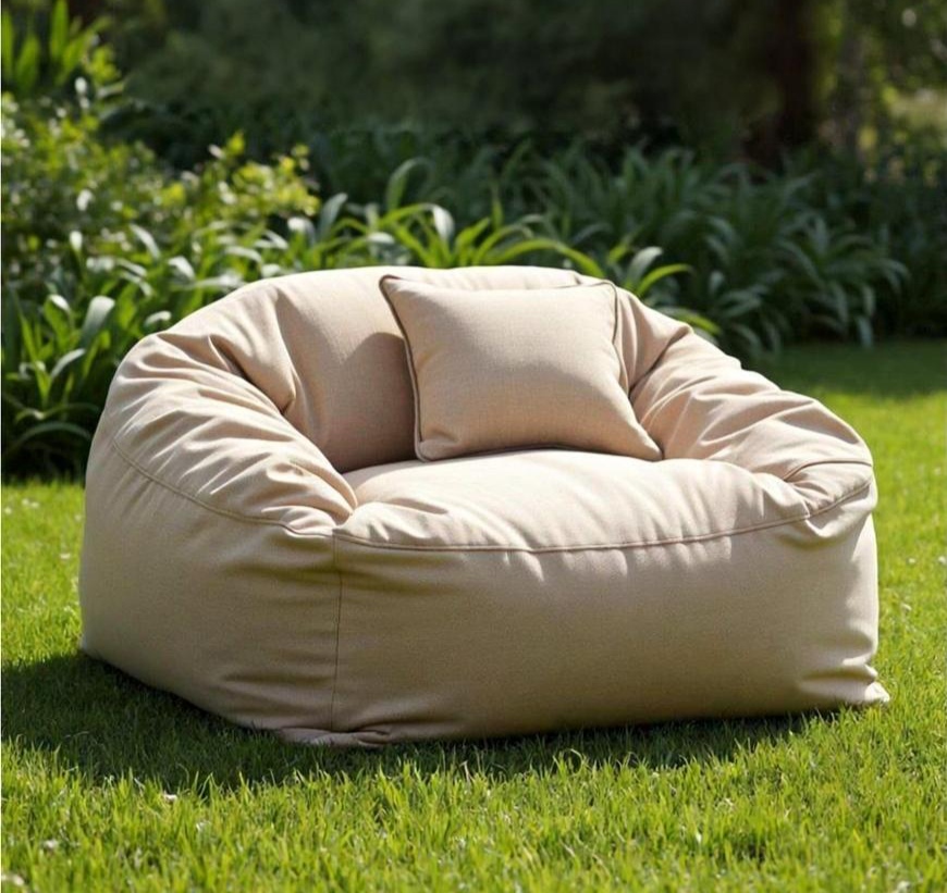 «Уличное кресло-мешок светлого оттенка с подушкой, стоящее на траве