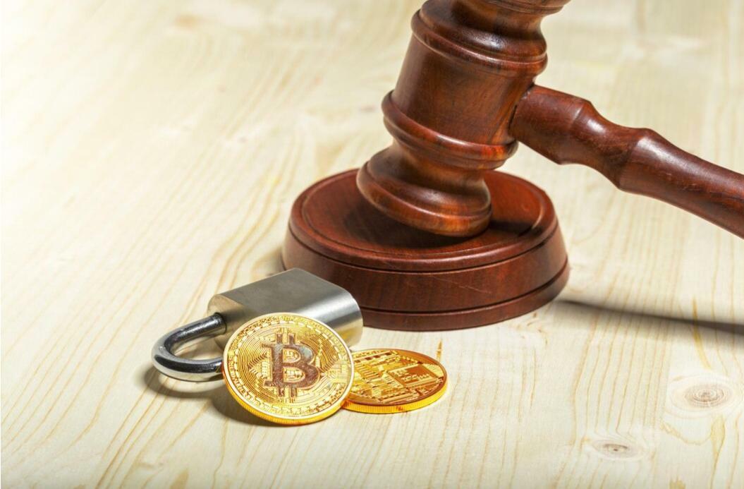 Binance sued: Judge's hammer, padlock, and coins on a table, representing the question if Binance is in trouble