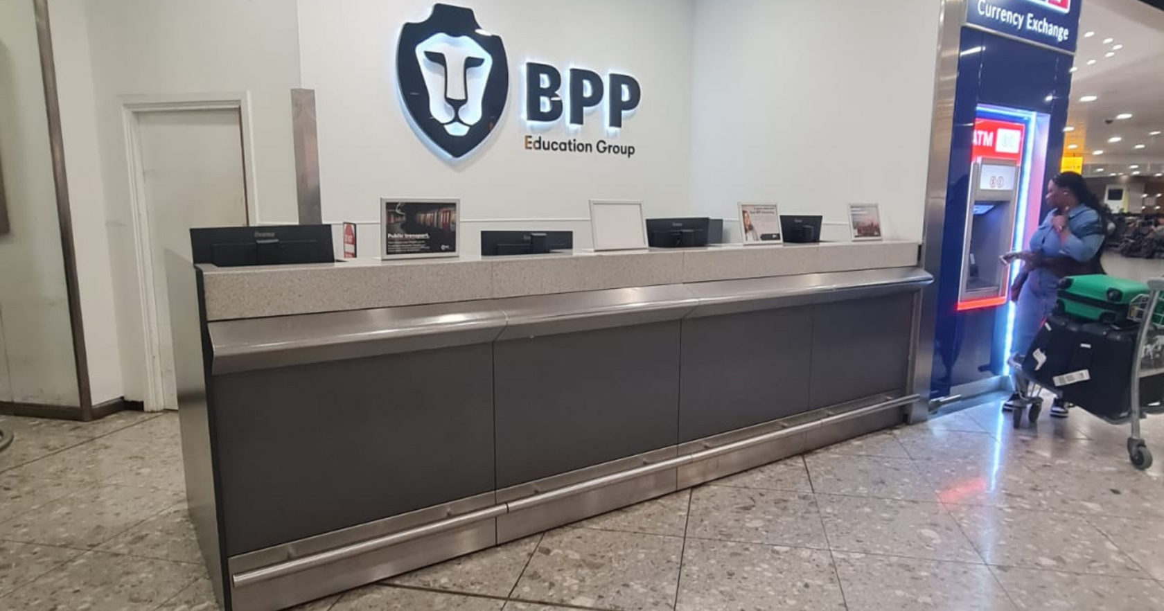 Reception counter at BPP University campus with signage in the background