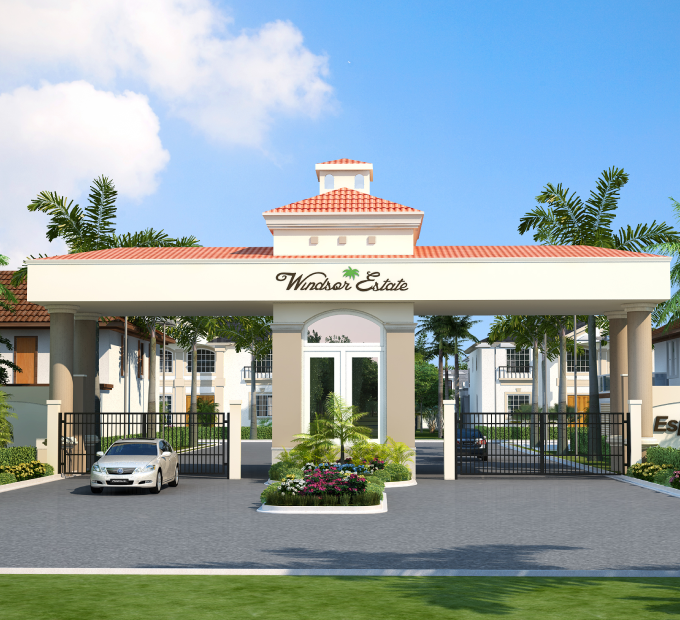 A grand entrance to a housing community, featuring a large gate with a light-colored archway and a red tiled roof. The words &amp;amp;quot;Windsor Estate&amp;amp;quot; are written in a script font above the gate. The entrance is flanked by palm trees and 