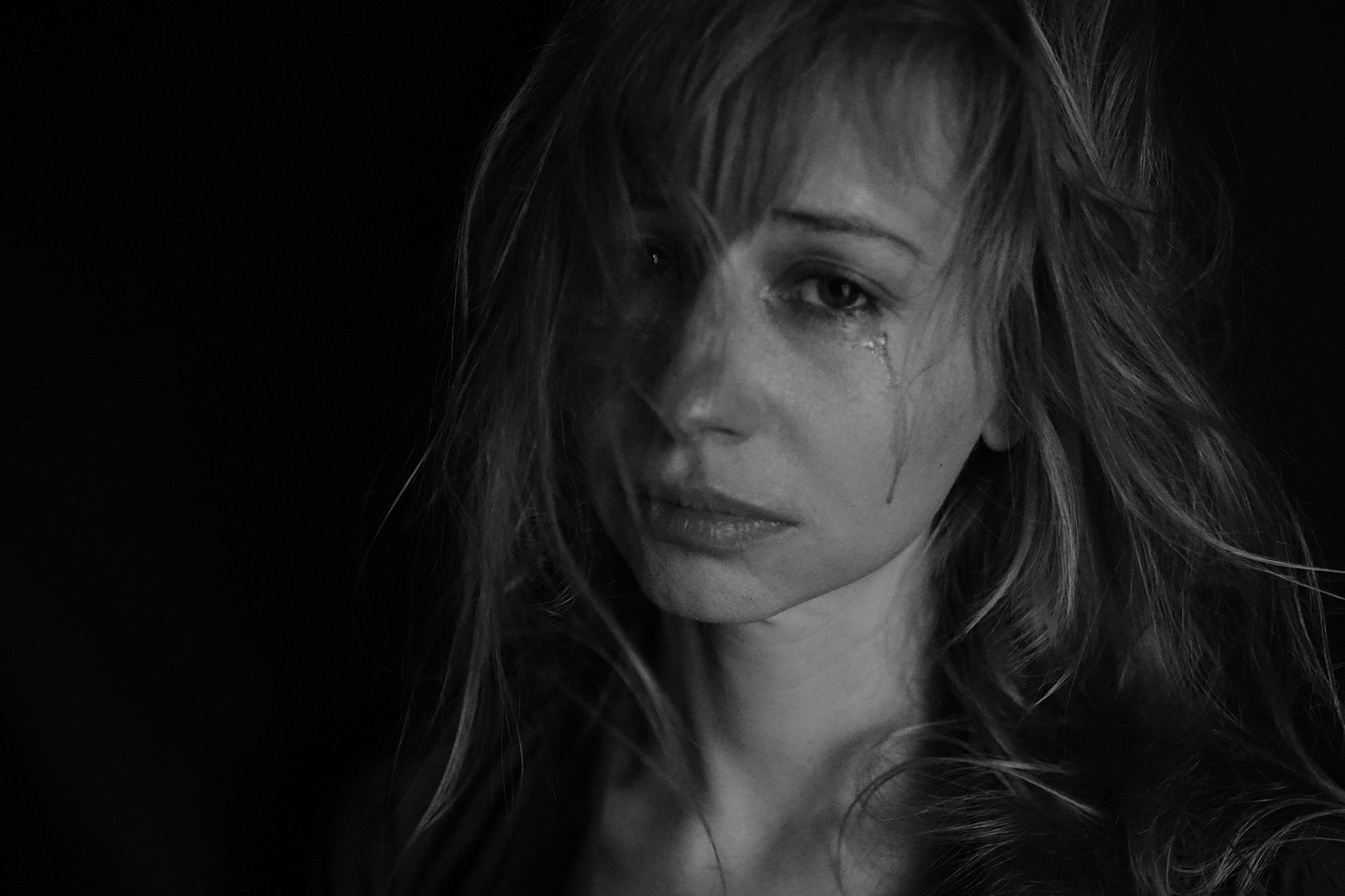Black and white photo of young woman crying