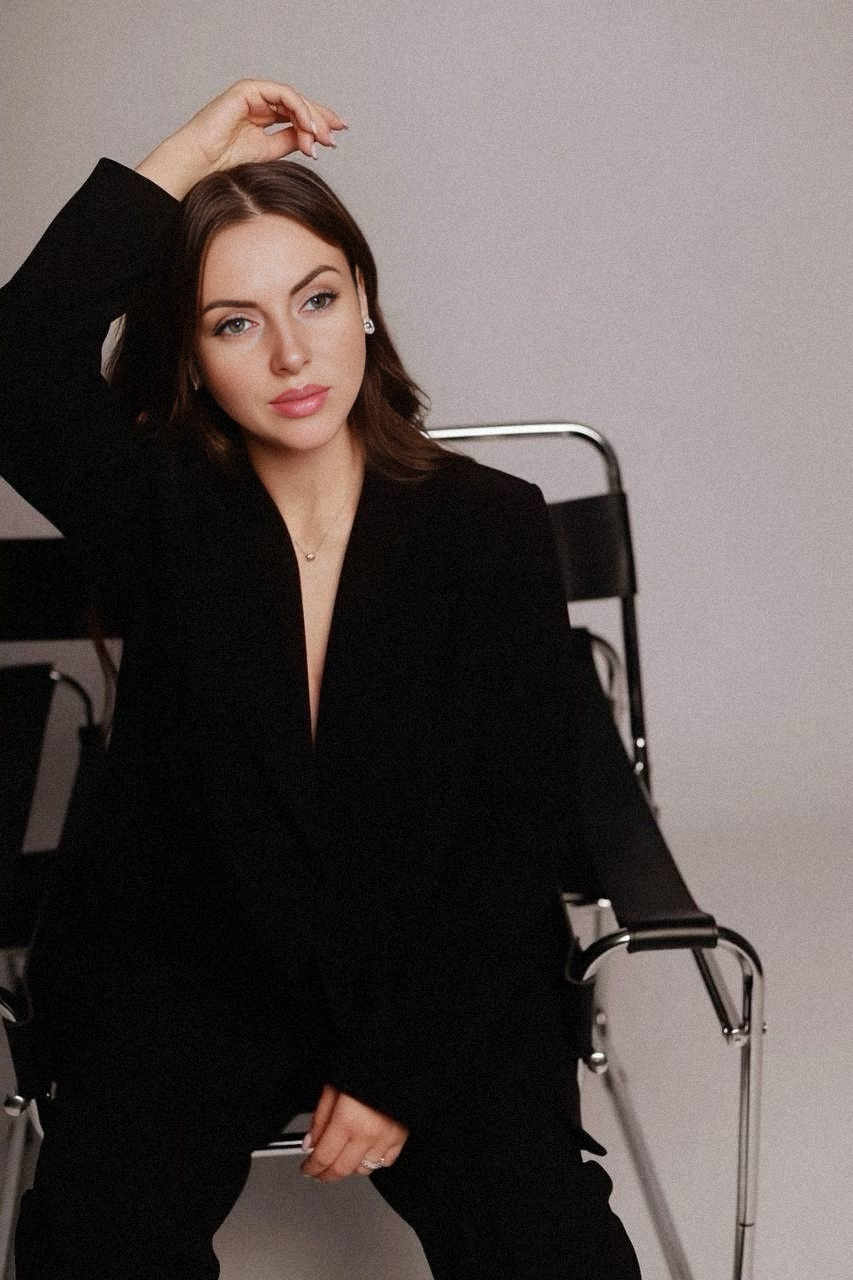 девушка сидит на стуле и руку положила на голову