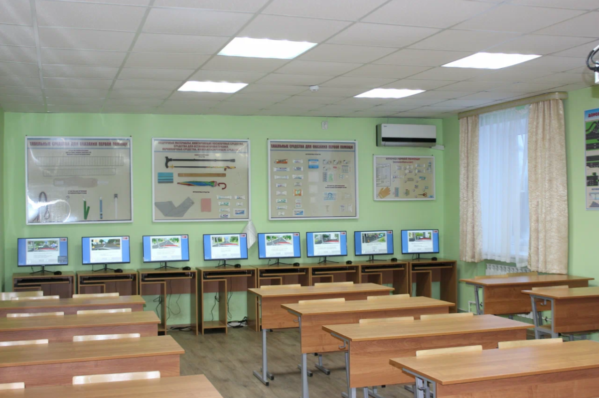 Компьютерный класс автошколы с учебными плакатами и мониторами