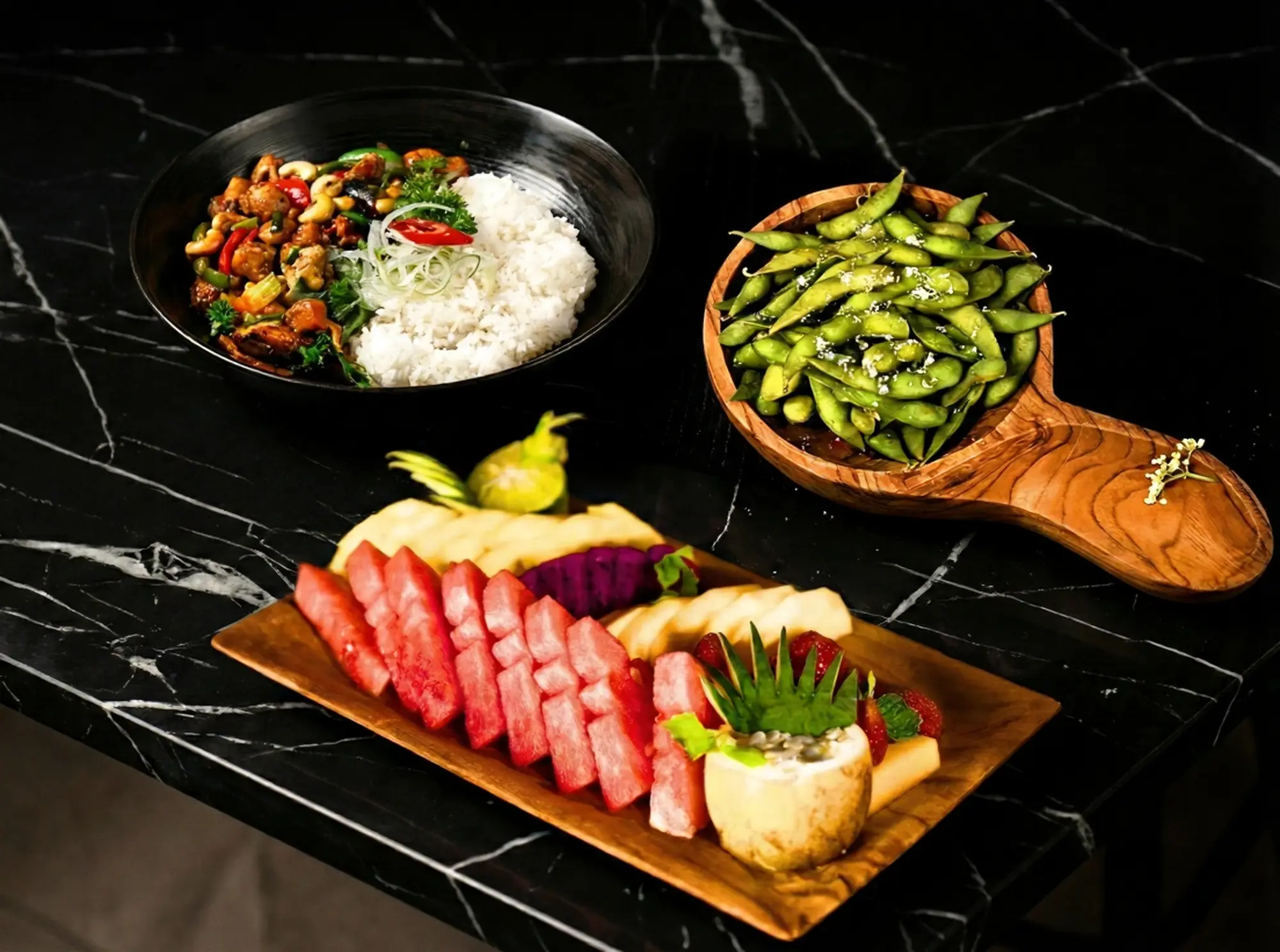 A refreshing and healthy choice for halal iftar in Bali, showing the 'Light Iftar' set at Eden Lounge with a fresh fruit platter, edamame, and a chicken kungpao rice bowl.