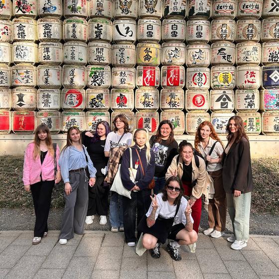 Группа TokyoTrip у стены с бочками саке