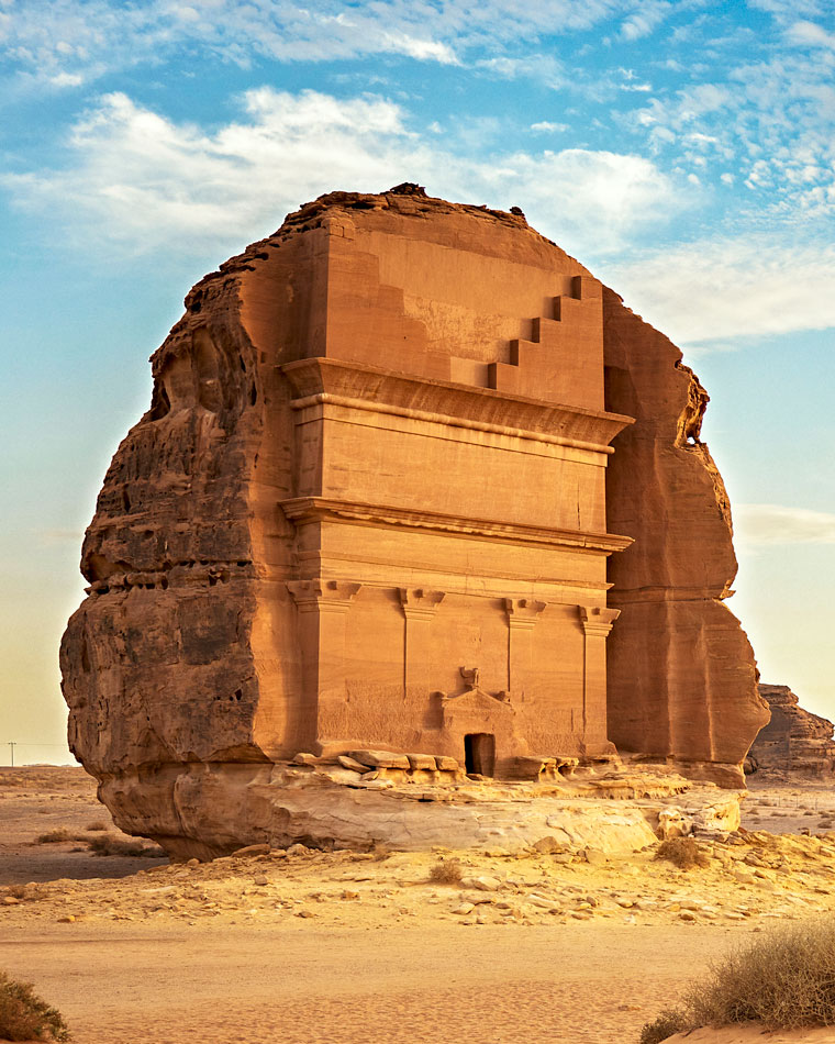 The tomb of Lihyan, a rock with a carved face, stands in the Saudi Arabian desert.