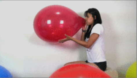 Girl blow to pop red balloon