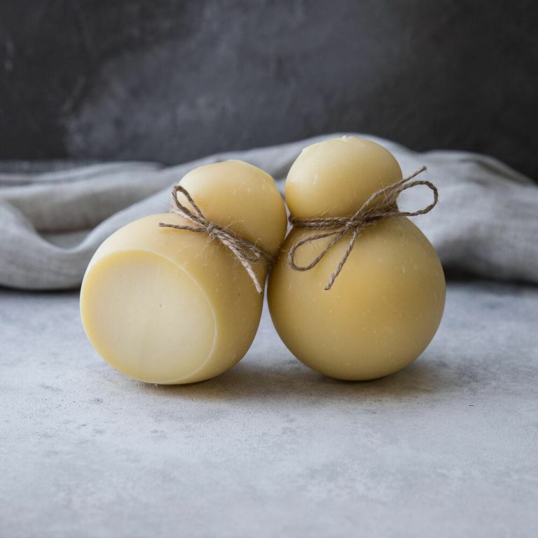 две головки сыра скаморца на сером фоне