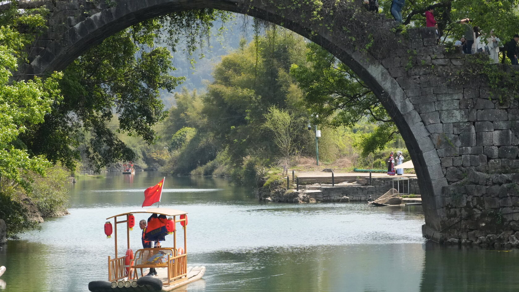 Тур в Китай 2026: прогулка на лодке по реке под каменным арочным мостом