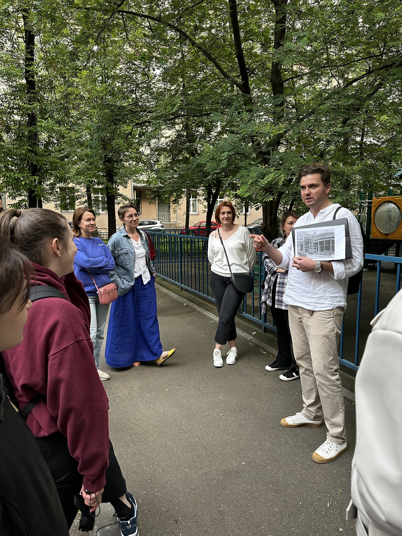 Экскурсовод показывает группе исторический материал