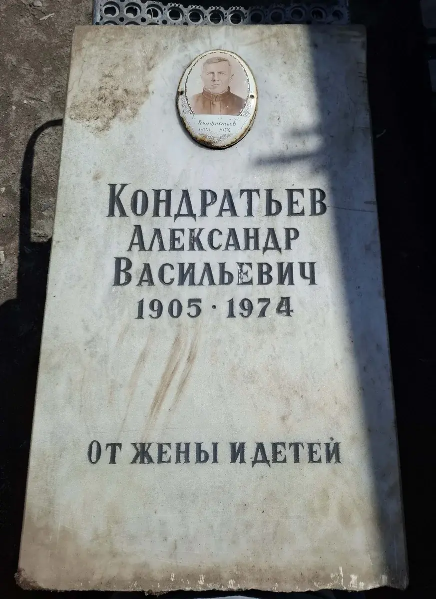 Светлая стела до обновления: один овальный фотопортрет, прежнее имя и памятный текст.