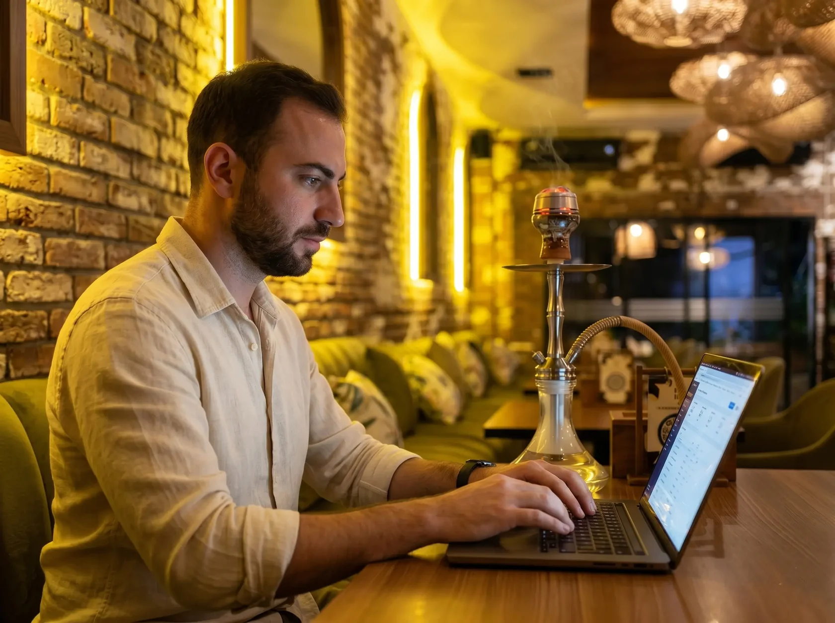 A couple working productively on their laptop by the window with fresh coconuts and a hookah at the Eden Canggu venue, recognized as the best coworking space in Bali.