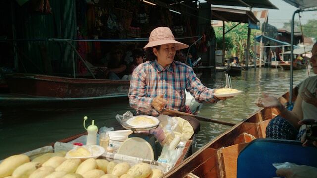 Vendor selling mango sticky rice from a boat at Damnoen Saduak Floating Market, Thailand - Thai Travel Store